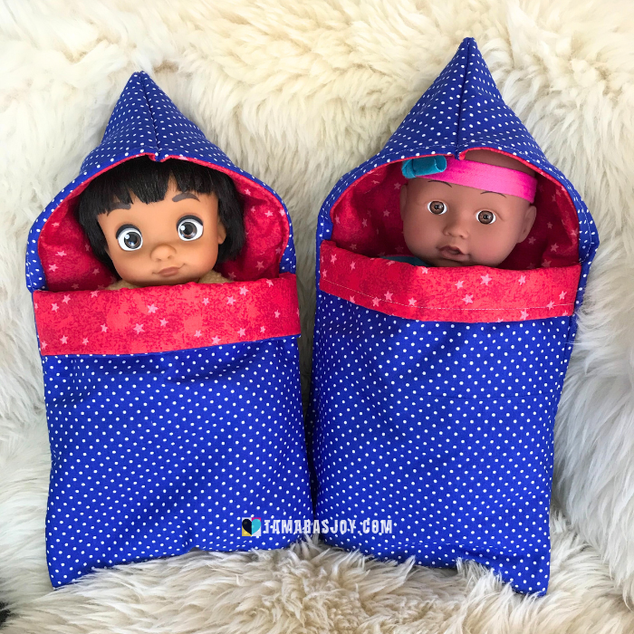 Image of two dolls in two doll sleeping bags.