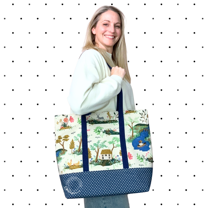 Woman holding a large tote bag with nature-themed design against a polka dot background