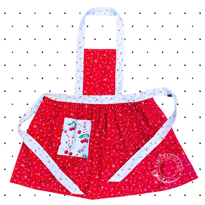 A red adult apron with a white polka dot pattern and a front pocket, featuring a neck and waist strap.